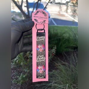 Bad Bunny black key fobe wristlet keychain with glitter purple on the inside.